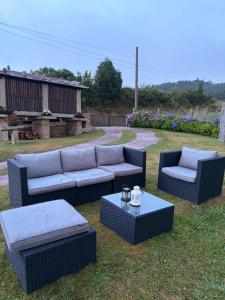 a group of couches and tables in a yard at Casa Pereiro playa de Esteiro in Viveiro