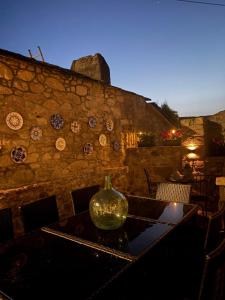 a vase sitting on a table in front of a stone wall at Casa Pereiro playa de Esteiro in Viveiro +65 photos