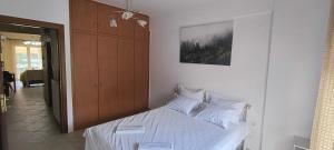 a bedroom with a bed with white sheets at DESPOINA APARTMENT 2 Relax in Nea Michaniona