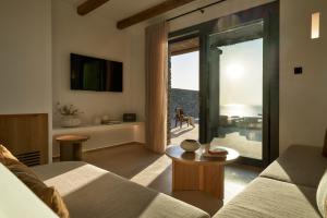 a living room with a couch and a large window at AOTO Villas in Kithnos