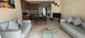 a living room with a couch and a table with chairs at DESPOINA APARTMENT 2 Relax in Nea Michaniona