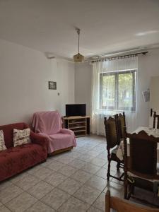 a living room with a red couch and a tv at Norma 2 in Novigrad Istria