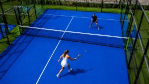 a man and a woman playing tennis on a tennis court at Grand Hotel Bansko - Fitness & SPA in Bansko