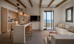 a kitchen and living room with a couch and a table at AOTO Villas in Kithnos