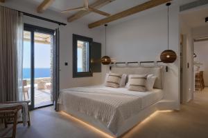 a bedroom with a bed with a view of the ocean at AOTO Villas in Kithnos +208 photos