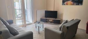 a living room with couches and a flat screen tv at DESPOINA APARTMENT 2 Relax in Nea Michaniona