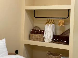 a bedroom with baskets on a shelf next to a bed at Pani house in Ko Samed +30 photos