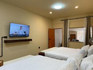 a bedroom with two beds and a flat screen tv at Pani house in Ko Samed