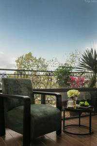 a green chair and a table on a balcony at Ryan Barnett home in Puerto Deseado