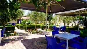 a table and chairs under an umbrella in a garden at Vila Flamuri in Golem