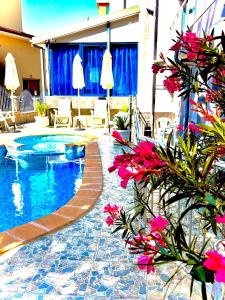 a swimming pool with pink flowers next to a building at Boutique Hotel Royal in Nesebar