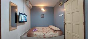 a small room with a bed and a television at LA MOTEL in Sungai Petani