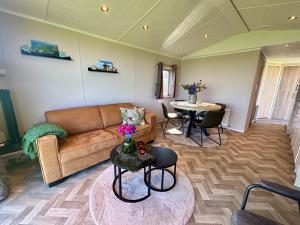 a living room with a couch and a table at Chalet direct aan Waddenzee in Westerland
