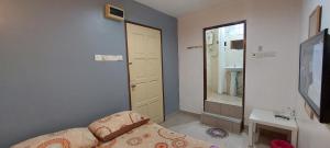a small bedroom with a bed and a bathroom at LA MOTEL in Sungai Petani