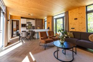 a living room with a couch and a table at Zicht op Twente - Spa lodges in Markelo