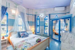 a bedroom with a bed with blue walls and windows at Paco's Resort Superior Villa 7 in Oziás +13 photos