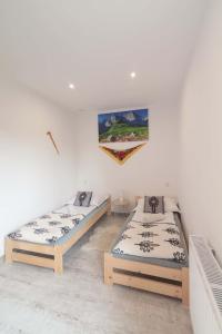 a room with two beds and a painting on the wall at Apartament i Pokoje u Moniki in Witów