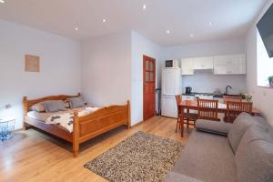 a bedroom with a bed and a kitchen with a table at Apartament i Pokoje u Moniki in Witów