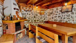 a dining room with a wooden table and a fireplace at Dima Suites Bansko - Vihren view & free parking in Bansko