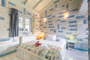 a bedroom with a bed and a brick wall at Paco's Resort Standard Studio 2 in Oziás