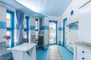 a blue and white bathroom with a table and chairs at Paco's Resort Superior Villa 6 in Oziás +14 photos