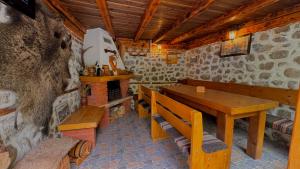 a dining room with a wooden table and a bench at Dima Suites Bansko - Vihren view & free parking in Bansko
