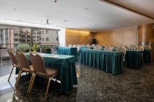 ein Konferenzraum mit grünen Tischen und Stühlen in der Unterkunft Hotel Nexta Escaldes in Andorra la Vella + 69 Fotos
