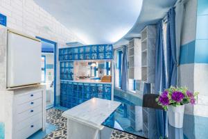 a bathroom with blue tiled walls and a sink at Paco's Resort Superior Villa 6 in Oziás