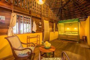 a room with a bed and a chair and a table at Palm Paradise Cabanas & Villas Beach Resort in Tangalle