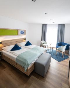 a bedroom with a large bed and a blue rug at Berghotel Kristall in Idar-Oberstein