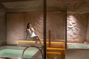 a woman in a white dress sitting on the edge of a tub at KiN Hotel Onsen in Ho Chi Minh City