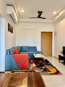 a living room with a blue couch and a table at Sky height 2BHK in GIFT CITY in Gandhinagar