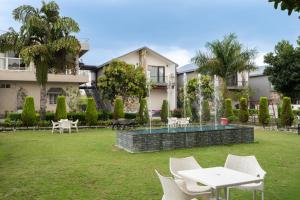 a building with a yard with white tables and chairs at Justa Natures Nest Resort in Bullāwāla