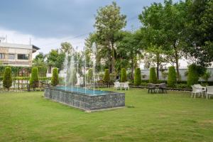 a fountain in a park with tables and chairs at Justa Natures Nest Resort in Bullāwāla