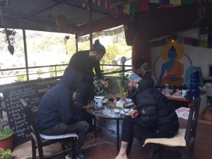two men sitting at a table in a restaurant at Sweet Dreams Guest house in Pokhara
