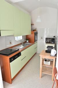 a kitchen with green cabinets and a sink and a table at Donna Lina Home- Enjoy Apulia in Monopoli +6 photos