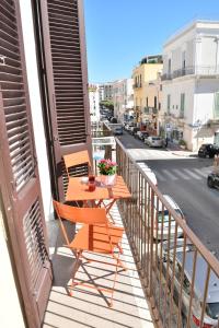 a table and chairs on a balcony with a street at Donna Lina Home- Enjoy Apulia in Monopoli