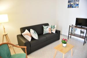 a living room with a black couch and a table at Donna Lina Home- Enjoy Apulia in Monopoli
