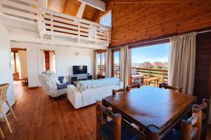 a living room with a table and a couch at Beach Cabin with a pool in Port Alfred