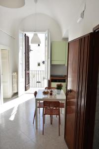a kitchen with a table and chairs and a kitchen with green cabinets at Donna Lina Home- Enjoy Apulia in Monopoli