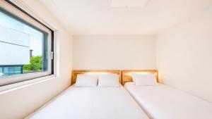 two beds in a small room with a window at Anguk House # Private 2F-3F Rooftop # Gyeongbokgung 1min # Bukchon in Seoul