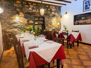 a dining room with tables with red and white tablecloths at Tamahuche Hotel Rural in Vallehermoso +34 photos