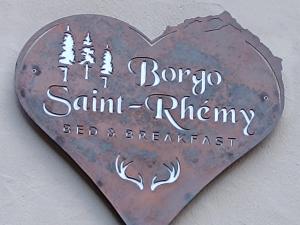 a heart with a sign that reads born to sirmily bed and breakfast at B&B Borgo Saint-Rhémy in Saint-Rhémy-en-bosses