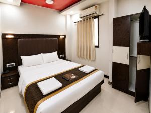 a bedroom with a large bed and a television at Hotel Taj Palace - Near Mumbai Airport in Mumbai