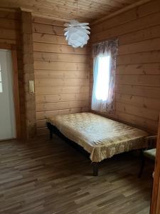 a bedroom with a bed in a log cabin at Villa SULKAVANRANTA in Sulkava