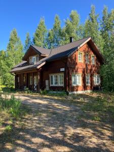 a large wooden house with a large yard at Villa SULKAVANRANTA in Sulkava