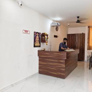 a man standing at the counter of a restaurant at Atithi Lodging in Ale