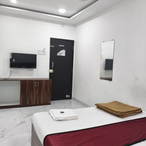 a room with a bed and a tv and a mirror at Atithi Lodging in Ale +33 photos
