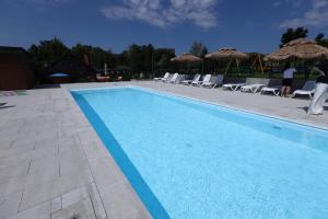 a large swimming pool with chairs and umbrellas at Przystanek Zapotocze in Słopnice