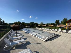 a row of lounge chairs and umbrellas on a patio at Przystanek Zapotocze in Słopnice
